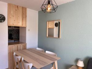 - une salle à manger avec une table et des chaises en bois dans l'établissement Plein centre station vue imprenable, à La Mongie