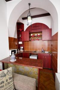 a kitchen with red cabinets and a wooden counter top at Pensiunea Noemi in Braşov
