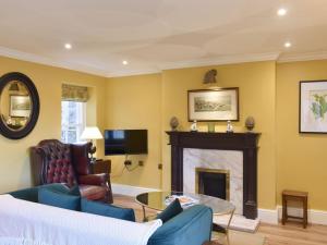 a living room with a fireplace and a tv at 3 The Reading Room Cottages - Uk31802 in Barningham