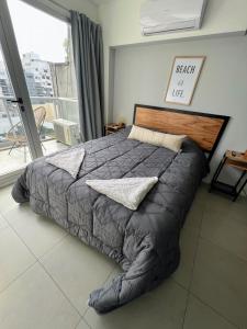 duże łóżko w sypialni z dużym oknem w obiekcie Palermo Medrano Studio Suits w BuenosAires