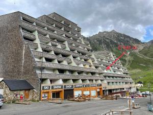 um grande edifício de apartamentos com uma seta vermelha em Plein centre station vue imprenable em La Mongie