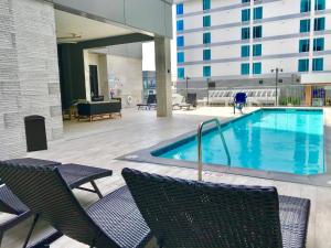 a swimming pool with chairs and a building at Holiday Inn & Suites Nashville Downtown Broadway in Nashville