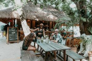 a group of people sitting at a table outside a restaurant at Selina Playa Del Carmen in Playa del Carmen