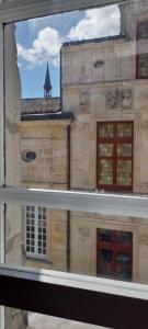 una ventana con vistas a un edificio en LA ROCHELAISE : Appartement calme & somptueux dans l'hyper centre. en La Rochelle