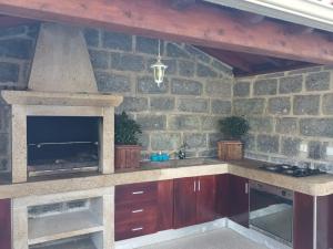 cocina con pared de piedra y chimenea en Casa da rosinha - Minho, Portugal, en Arcos de Valdevez