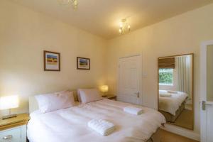 a bedroom with a large white bed and a mirror at Park Crescent apartment in York