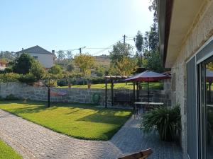un patio con mesa y sombrilla en Casa da rosinha - Minho, Portugal, en Arcos de Valdevez