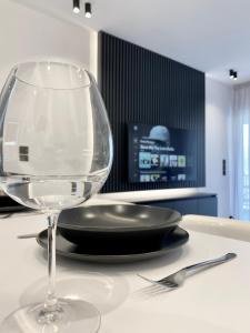 a wine glass sitting next to a plate on a table at Seafront Apartment by C2C Architects in Kalívia Thorikoú