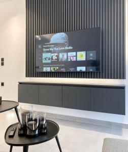 ein Wohnzimmer mit einem Flachbild-TV an der Wand in der Unterkunft Seafront Apartment by C2C Architects in Kalívia Thorikoú