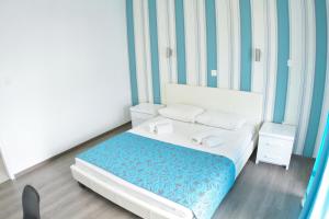 een slaapkamer met een bed met blauwe en witte strepen bij Margarita Napa Apartments in Ayia Napa