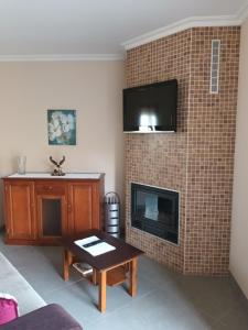 sala de estar con TV en una pared de ladrillo en Casa da rosinha - Minho, Portugal, en Arcos de Valdevez