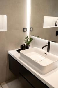 ein Badezimmer mit einem weißen Waschbecken und einem Spiegel in der Unterkunft Seafront Apartment by C2C Architects in Kalívia Thorikoú