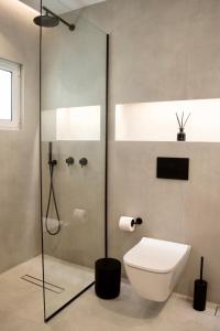 a bathroom with a toilet and a glass shower at Seafront Apartment by C2C Architects in Kalívia Thorikoú