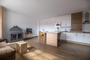 kuchnia i salon z kanapą i kominkiem w obiekcie El Rincón de Ramón II w mieście Cortijos Nuevos