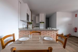 mesa de comedor con sillas y cocina en El Rincón de Ramón II, en Cortijos Nuevos