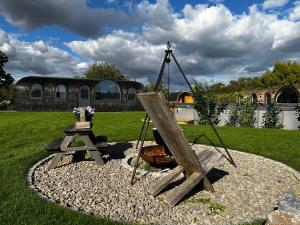 a garden with a wooden swing and a fire hydrant at Tirolian Lodge East in Bundorf