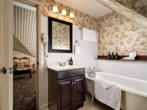 a bathroom with a bath tub and a sink and a bath tub at Pendray Inn and Tea House in Victoria