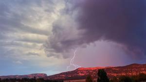 哈奇的住宿－The Riverside Ranch Motel and RV Park Southern Utah，山上空的闪电风暴