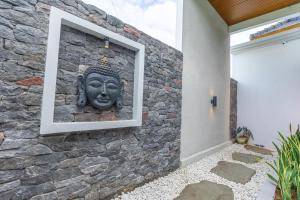 a stone wall with a statue on a wall at Villa Sokhaya in Ubud