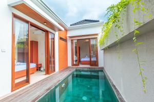 a house with a swimming pool next to a building at Villa Sokhaya in Ubud