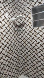 a bathroom with a brown and white patterned wall at Incrivel chacara com pisc e churrasq em Extrema MG in Extrema