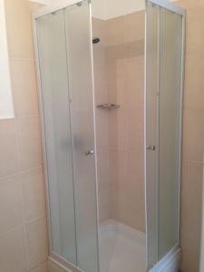 um chuveiro com portas de vidro na casa de banho em Apartment Silvana em Šibenik