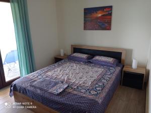 a bedroom with a bed with a quilt on it at Sunset Apartment in Epanomi