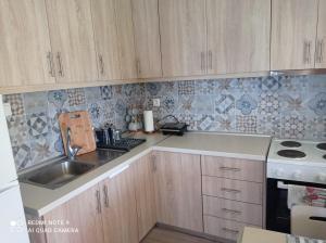 a kitchen with wooden cabinets and a sink at Sunset Apartment in Epanomi