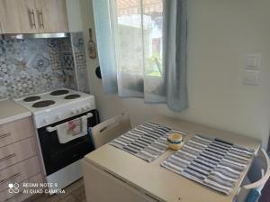 a kitchen with a stove and a table with chairs at Sunset Apartment in Epanomi