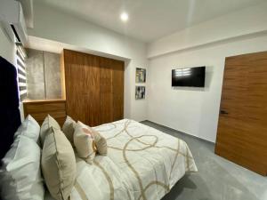a bedroom with a bed with a television on the wall at Departamento catania con vista al mar in Mazatlán