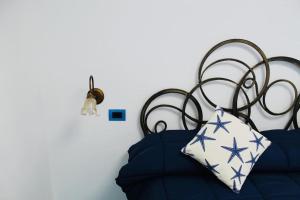 un letto con lenzuola blu e un cuscino sopra di Rifugio Stellato a Conca dei Marini