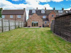 an empty yard in front of a house with a fence at 4 Greenhaye Cottages - Uk31236 in Newnham