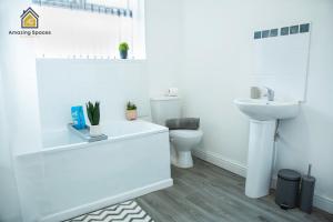 a white bathroom with a sink and a toilet at Spacious 3 Bed City Centre House for Large Groups and Contractors with Free Wifi by Amazing Spaces Relocations Ltd in Liverpool