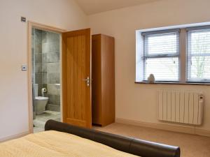 a bedroom with a bed and a bathroom with a shower at Swaledale Cottage - Barley Green Mill in Barrowford