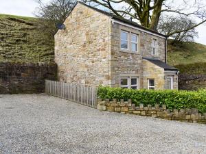 a stone house with a fence in front of it at Swaledale Cottage - Barley Green Mill in Barrowford