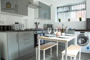 a kitchen with a table with wine glasses on it at Spacious 3 Bed City Centre House for Large Groups and Contractors with Free Wifi by Amazing Spaces Relocations Ltd in Liverpool