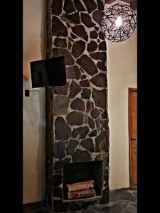 una chimenea de piedra con TV encima. en No 2 Loft Jacuzzi Mazamitla, en Mazamitla