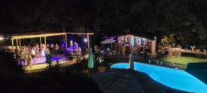 a group of people standing by a swimming pool at night at Gites San Austinu in Petreto-Bicchisano