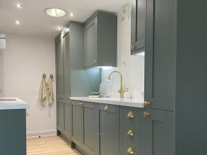 a kitchen with gray cabinets and a sink at Oakleigh in Old Brampton
