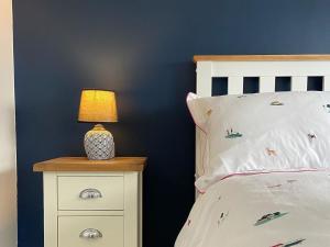 a bedroom with a bed with a lamp on a night stand at Oakleigh in Old Brampton