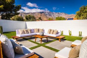 um pátio com sofás e mesas com montanhas ao fundo em White Pearl - Pool - Spa - Mountain Views em Palm Springs