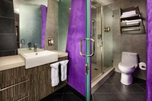 a purple bathroom with a sink and a toilet at The Moment Hotel in Los Angeles