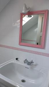 un lavandino da bagno con specchio rosso sopra di Quinta da Barbosa a Folgosinho