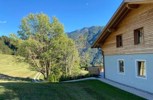 a house with a grass yard next to a tree at Valentin36 Apartment Ritten in Funes