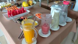 - une table avec deux verres de jus d'orange et d'autres boissons dans l'établissement Hotel Presidente, à Imperatriz