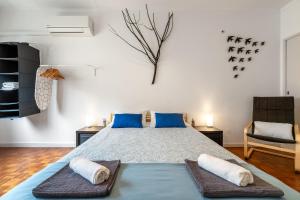 a bedroom with a large bed with blue pillows at Bordallo's Lodge in Caldas da Rainha