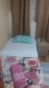 a small bedroom with a bed with flowers on it at Pousada Refúgio da Chapada in Cavalcante