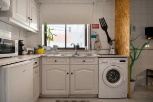 a kitchen with a sink and a washing machine at Bordallo's Lodge in Caldas da Rainha