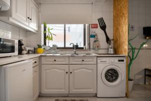 a kitchen with a sink and a washing machine at Bordallo's Lodge - centro Caldas da Rainha in Caldas da Rainha