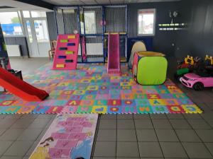 uma sala de jogos com um parque infantil com brinquedos no chão em Pansion Brod em Slavonski Brod